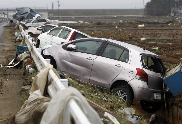 Image: Damaged cars are seen at an area that was devastated by the March 11 earthquake and tsunami, in Watari